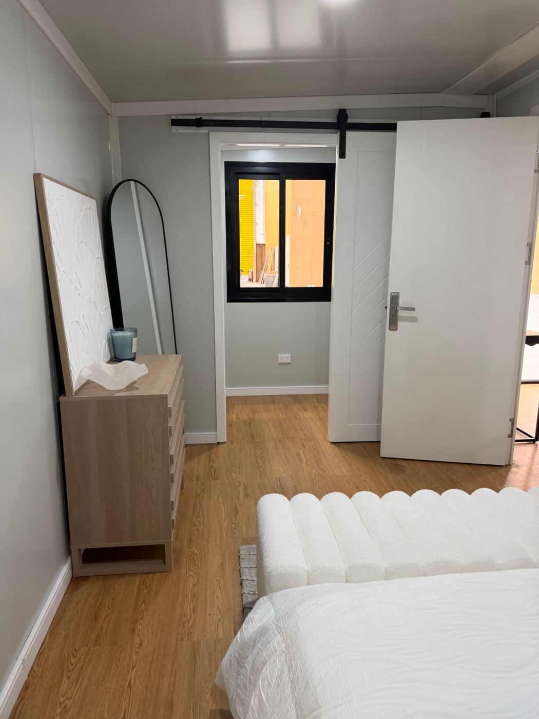 Bedroom looking through to the walk-in wardrobe with barn-style sliding door open