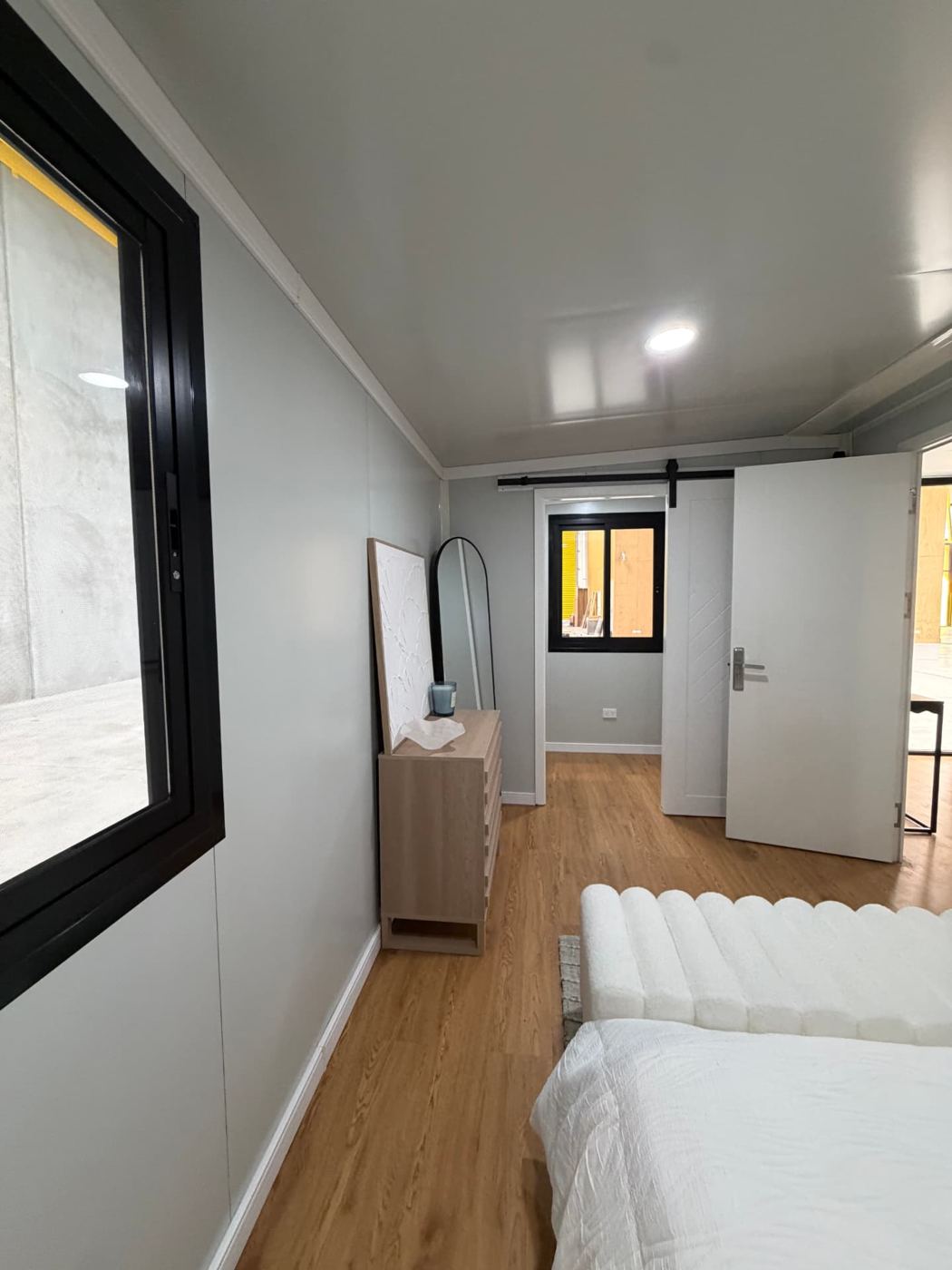 Wide view along the bedroom towards the barn-style sliding door