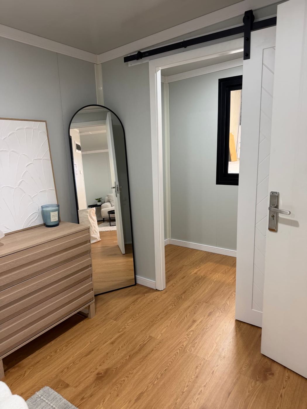 Arch mirror beside the open sliding door leading to the walk-in wardrobe
