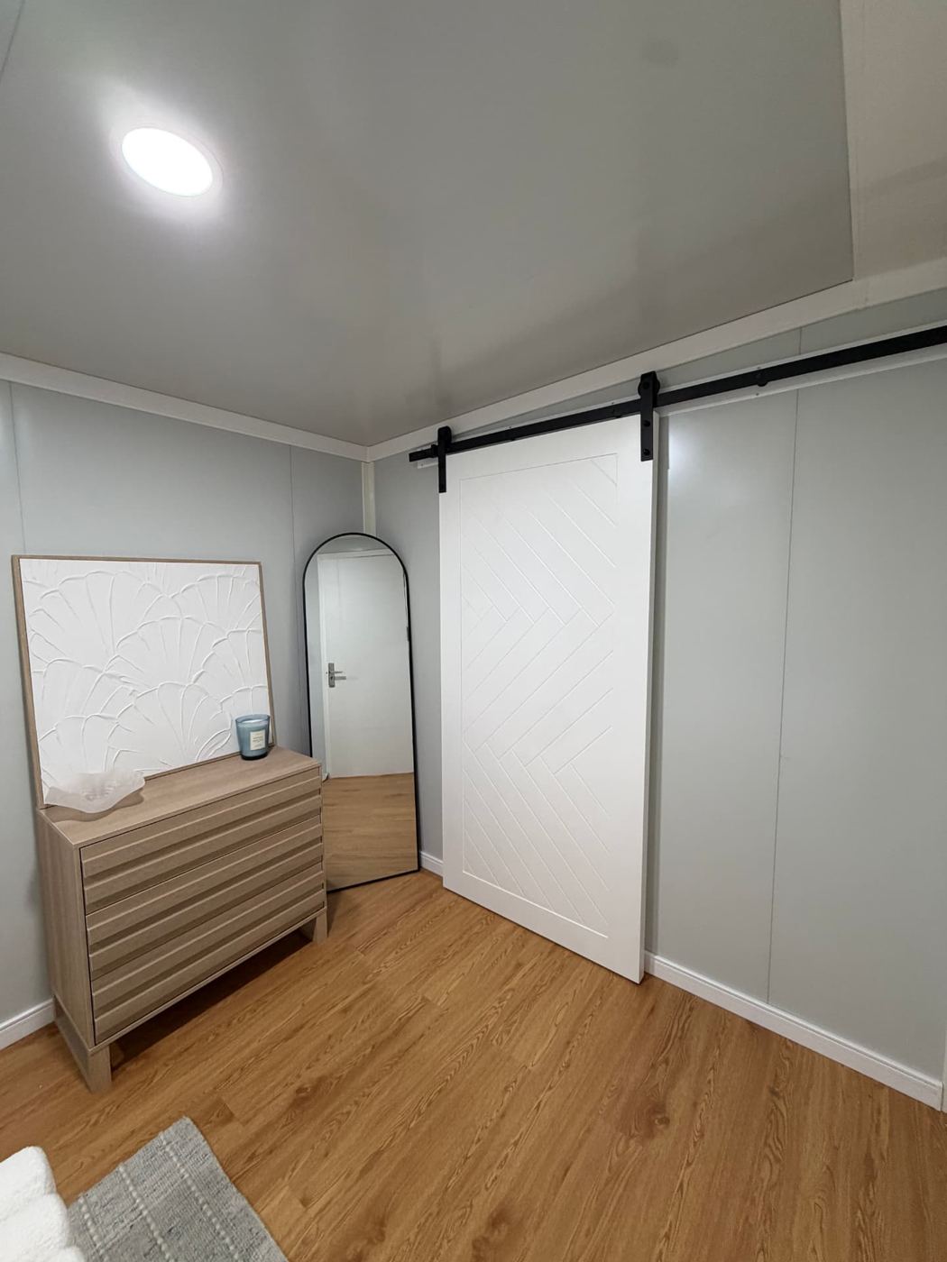 White barn-style sliding door on black track inside the bedroom