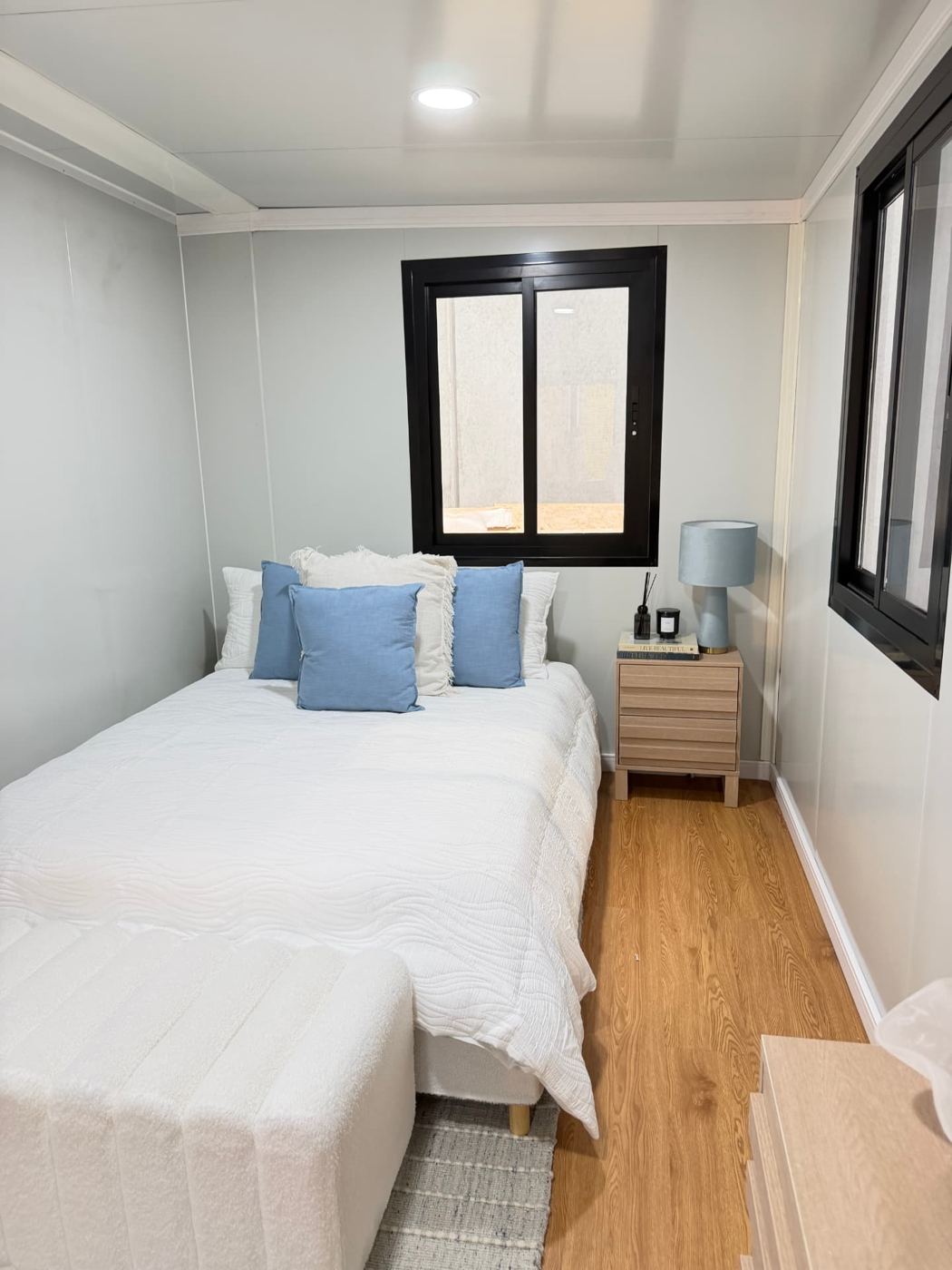 Bedroom interior showing bedside table, window and premium SPC flooring